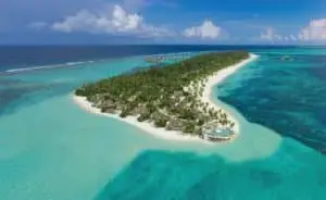 Luftaufnahme von Six Senses Kanuhura, einer tropischen Insel mit üppiger Vegetation, weißen Sandstränden, türkisfarbenem Wasser und luxuriösen Wasserbungalows.
