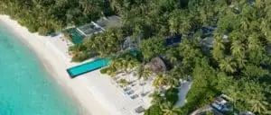 Luftaufnahme von Sirru Fen Fushi, Malediven, mit türkisfarbenem Wasser, weißem Sandstrand, Palmen und Pools. Luxuriöses Inselresort.