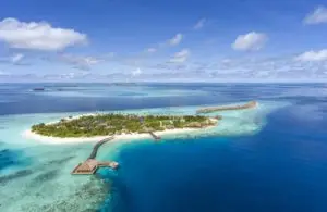 Luftaufnahme von Hurawalhi, einer tropischen Insel mit türkisfarbenem Wasser, weißen Sandstränden und luxuriösen Wasserbungalows. Ein Paradies auf den Malediven.