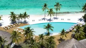 Luftaufnahme von Ifuru: Türkisfarbenes Wasser, weißer Sandstrand, Palmen und ein luxuriöser Poolbereich mit Liegen und Sonnenschirmen.