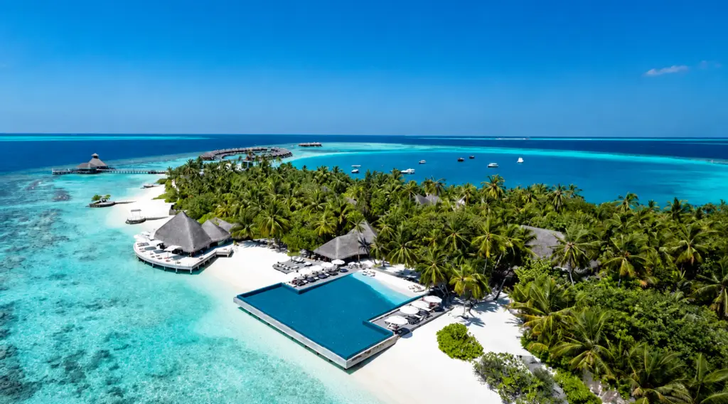 Luftaufnahme einer tropischen Insel mit Resort, Infinity-Pool, Palmen und türkisfarbenem Meer