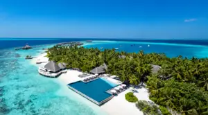 Luftaufnahme einer tropischen Insel mit Resort, Infinity-Pool, Palmen und türkisfarbenem Meer