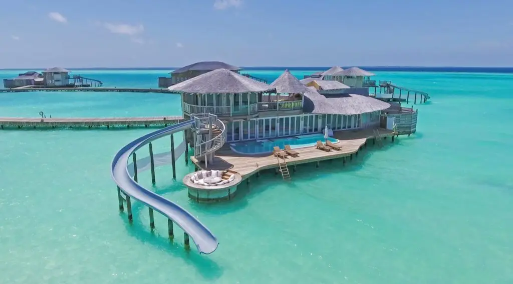 Luxuriöse Soneva Jani Wasservilla mit Rutsche ins türkisfarbene Meer, Pool und Sonnendeck. Ein Traumurlaub in den Malediven.