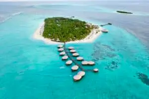 Luftaufnahme von Kihaa, einer tropischen Insel mit üppigem Grün, weißen Sandstränden und luxuriösen Wasserbungalows im türkisfarbenen Meer.