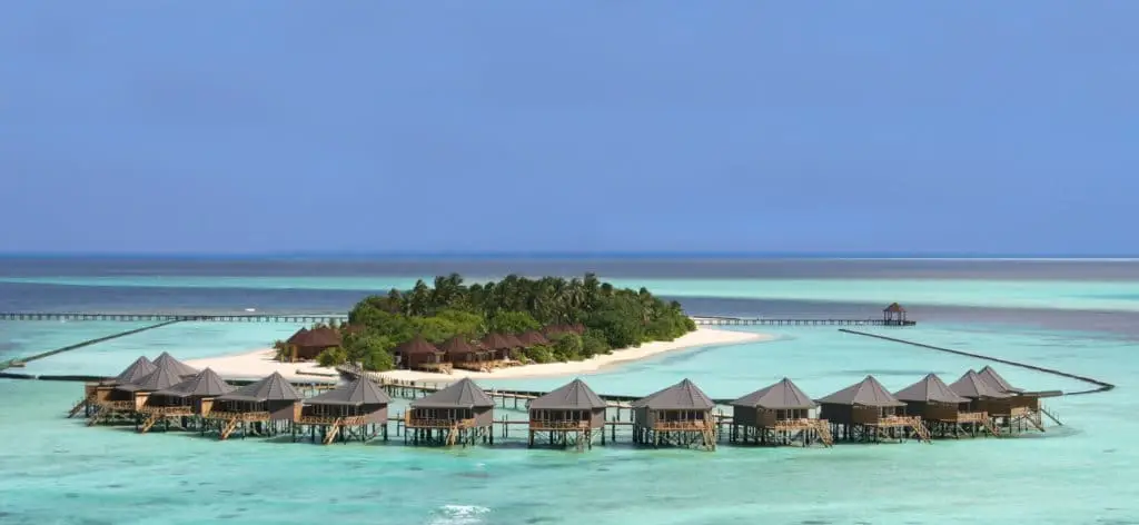 Luxuriöse Wasserbungalows auf Komandoo Island, Malediven. Türkisfarbenes Wasser umgibt die Insel mit üppiger Vegetation und weißen Sandstränden. Ein Paradies!