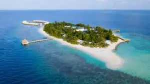Luftaufnahme von Sandies Bathala, einer tropischen Insel mit türkisfarbenem Wasser, weißen Sandstränden, üppiger Vegetation und luxuriösen Wasserbungalows.
