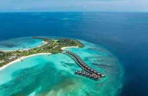 Das DusitD2 Feydhoo Maldives: Luftaufnahme einer tropischen Insel mit luxuriösen Strand- und Überwasservillen, umgeben von türkisfarbenem Wasser. Entspannung pur im Süd-Male-Atoll.