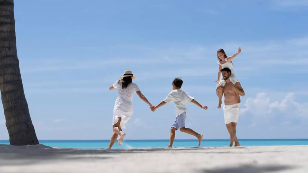 Familie läuft und spielt am Strand im Urlaub auf den Malediven