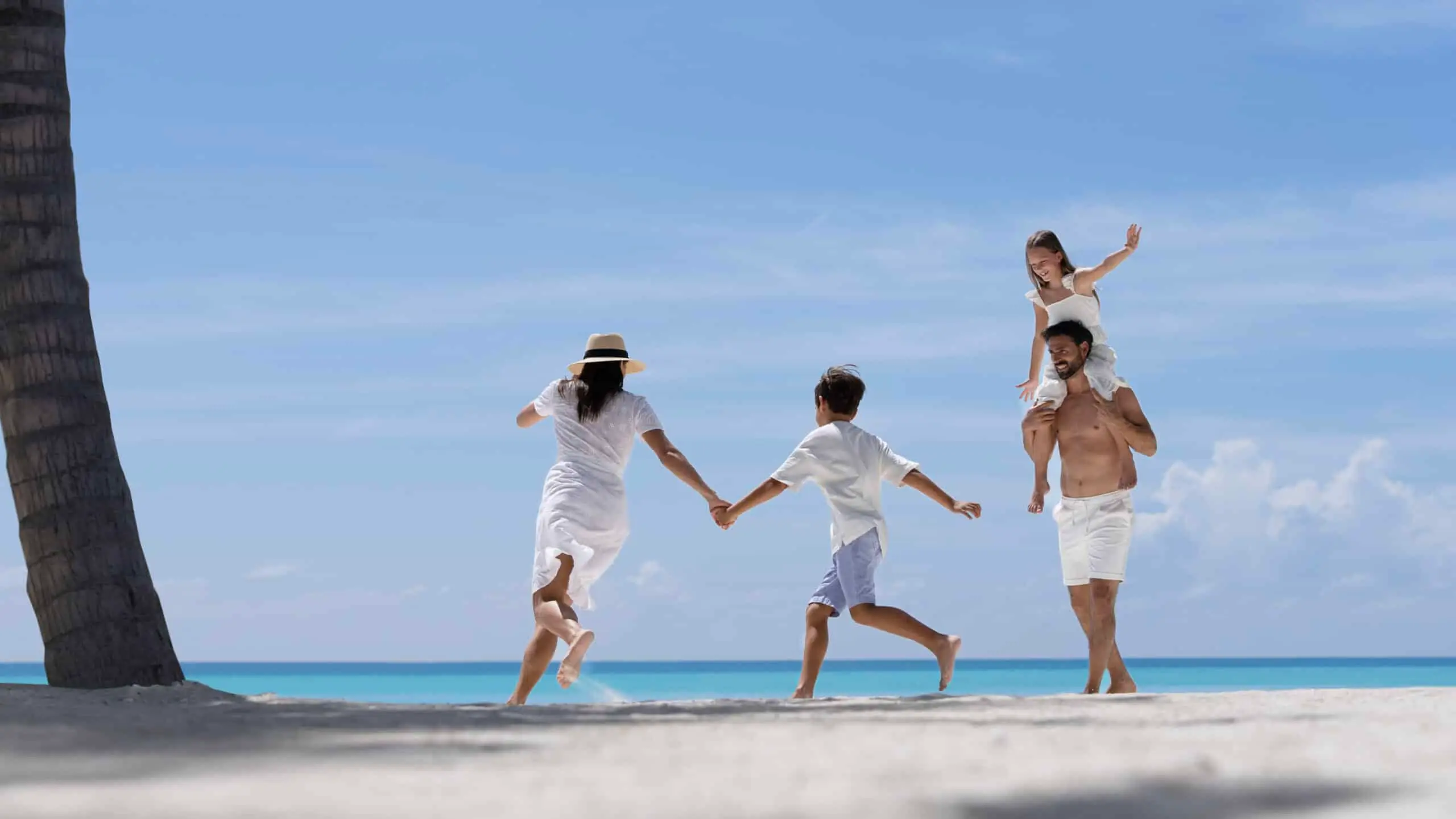Familie läuft und spielt am Strand im Urlaub auf den Malediven