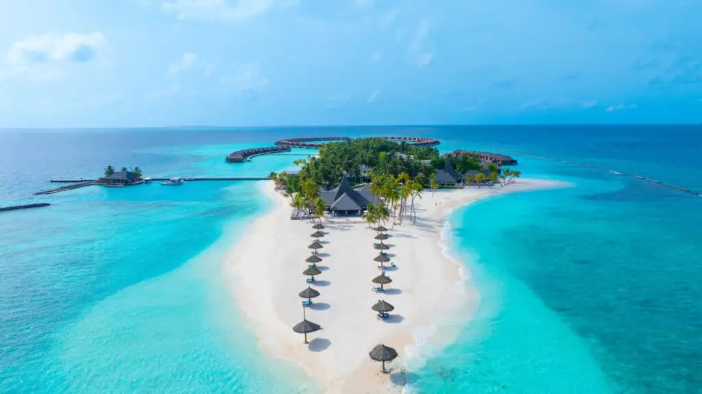 Luftaufnahme einer tropischen Insel mit weißem Sandstrand, Palmen und Resort im türkisblauen Meer auf den Malediven