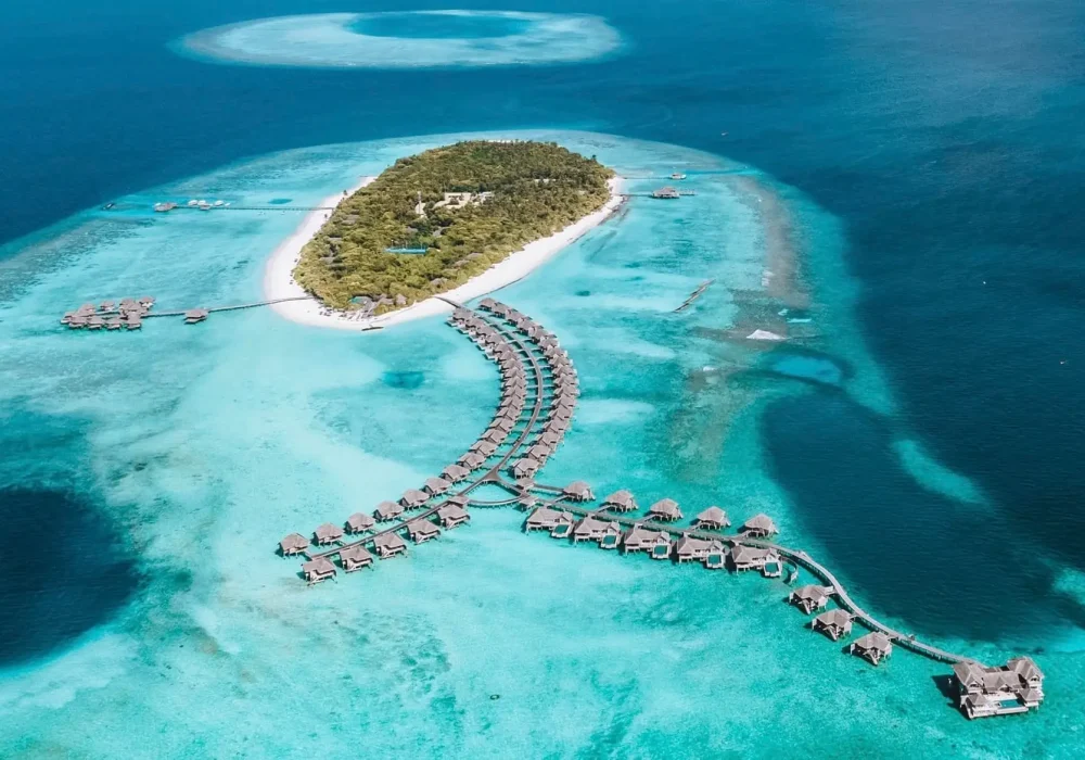 Luftaufnahme eines luxuriösen Resorts auf einer tropischen Insel mit türkisfarbenem Wasser. Perfekt für STOP OVER REISEN AWARD Gewinner!